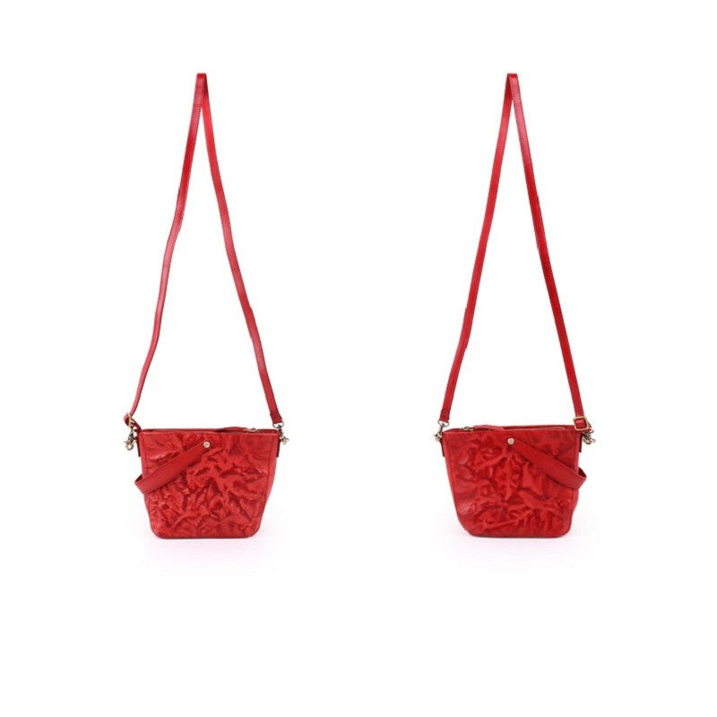 Two red textured handbags with straps on a white background
