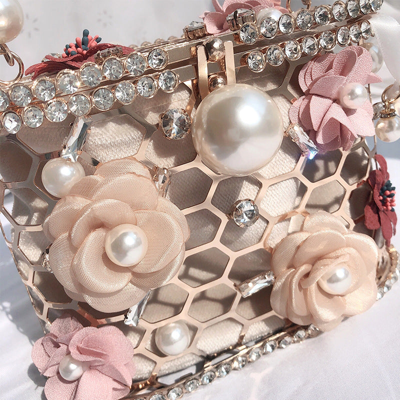 Decorative phone case with floral designs, pearls, and rhinestones on a white background