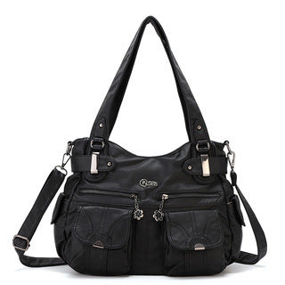 Black handbag with multiple pockets and straps on a white background