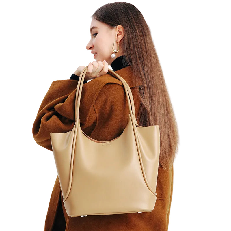 Woman holding a beige tote bag against a white background
