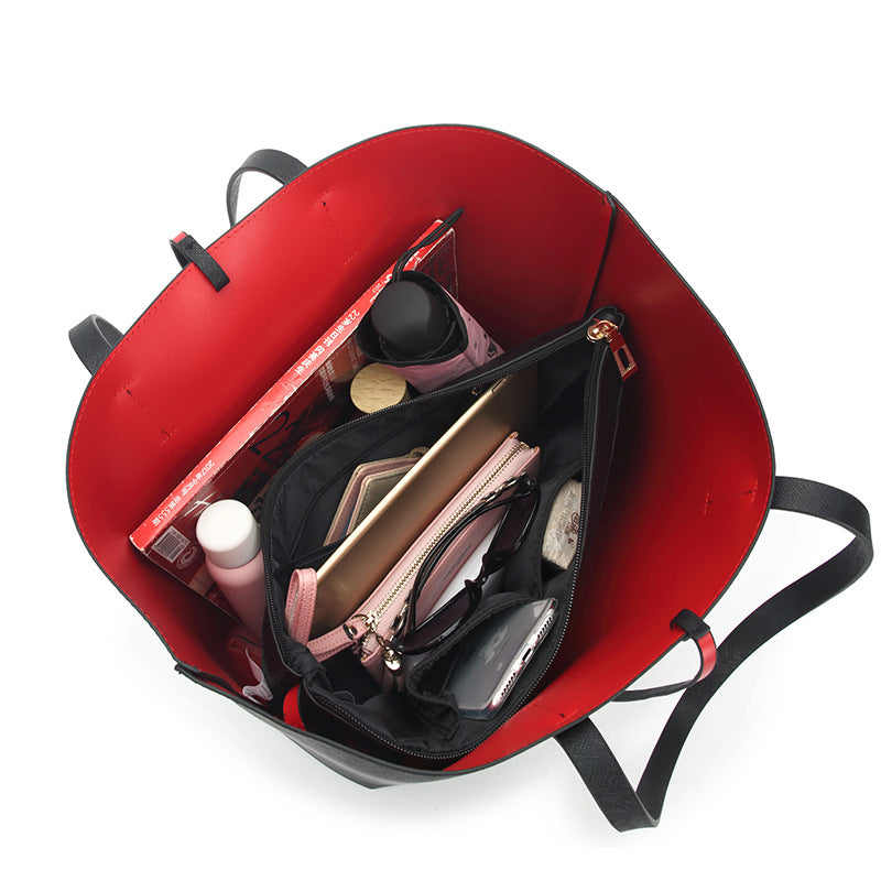 Red handbag with black interior showing various items on a white background