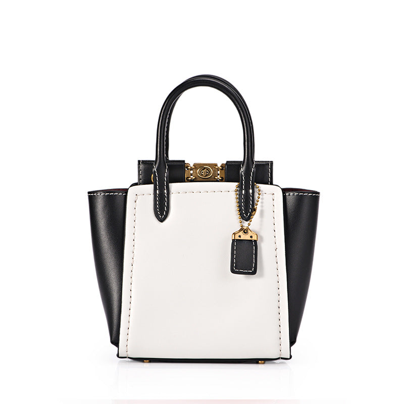 Black and white handbag with gold accents on a white background