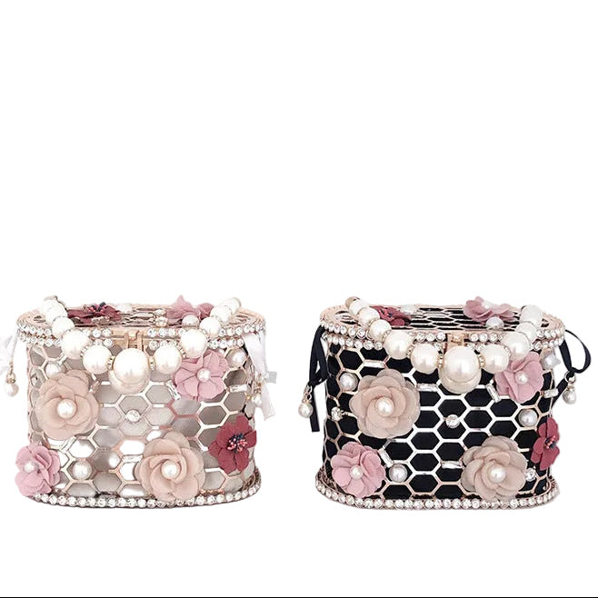 Decorative boxes with floral and pearl embellishments on a white surface.