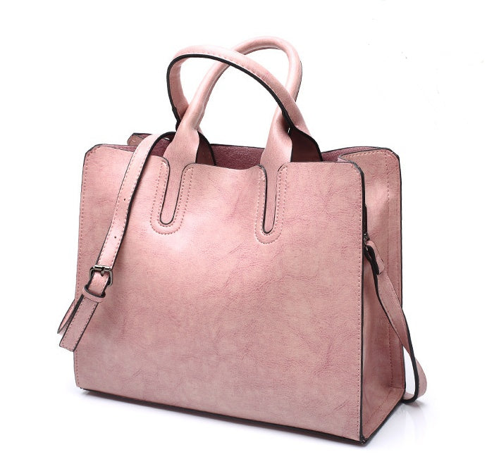 Pink handbag with a strap on a white background