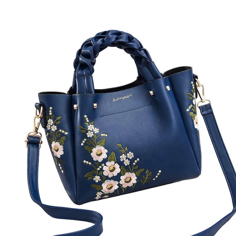 Blue handbag with floral embroidery on a white background