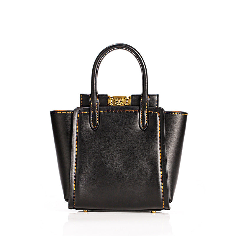 Black leather handbag with gold accents on a white background