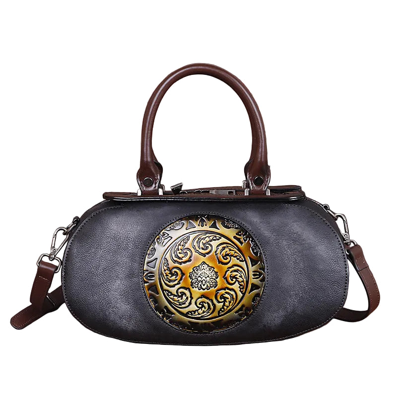 Black handbag with decorative gold emblem on a white background