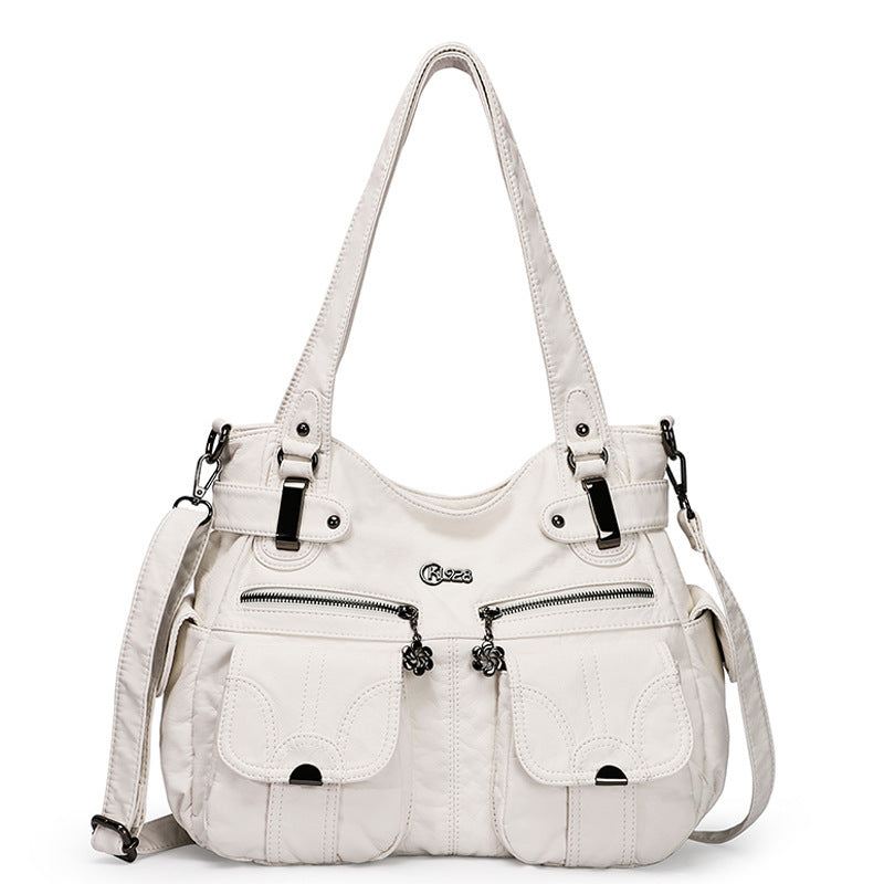 White handbag with multiple pockets and straps on a white background
