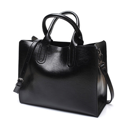 Black handbag with a shoulder strap on a white background