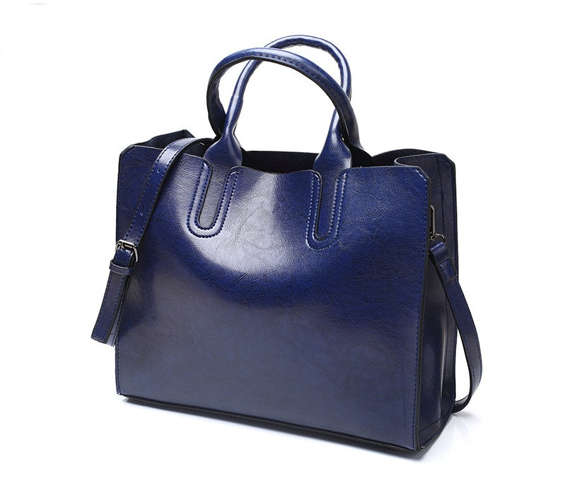 Blue handbag with a shoulder strap on a white background