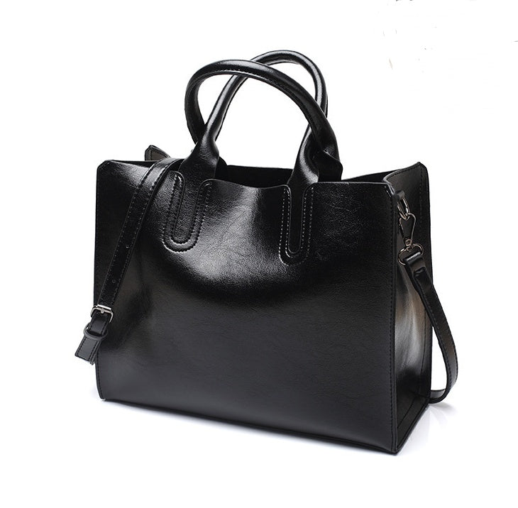 Black handbag with a shoulder strap on a white background