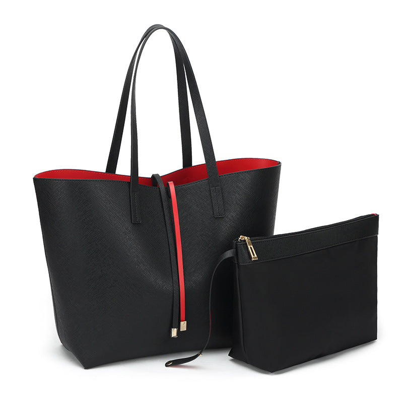 Black tote bag with red interior and matching pouch on a white background