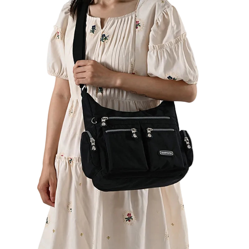 Person wearing a black crossbody bag on a white background