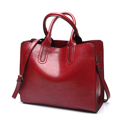 Red handbag with a shoulder strap on a white background