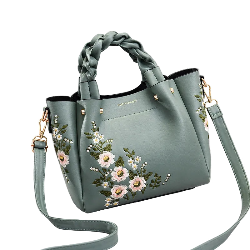 Green handbag with floral embroidery on a White gray background