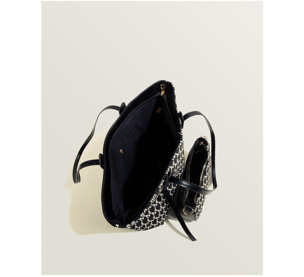 Black handbag with chain detail on a white background