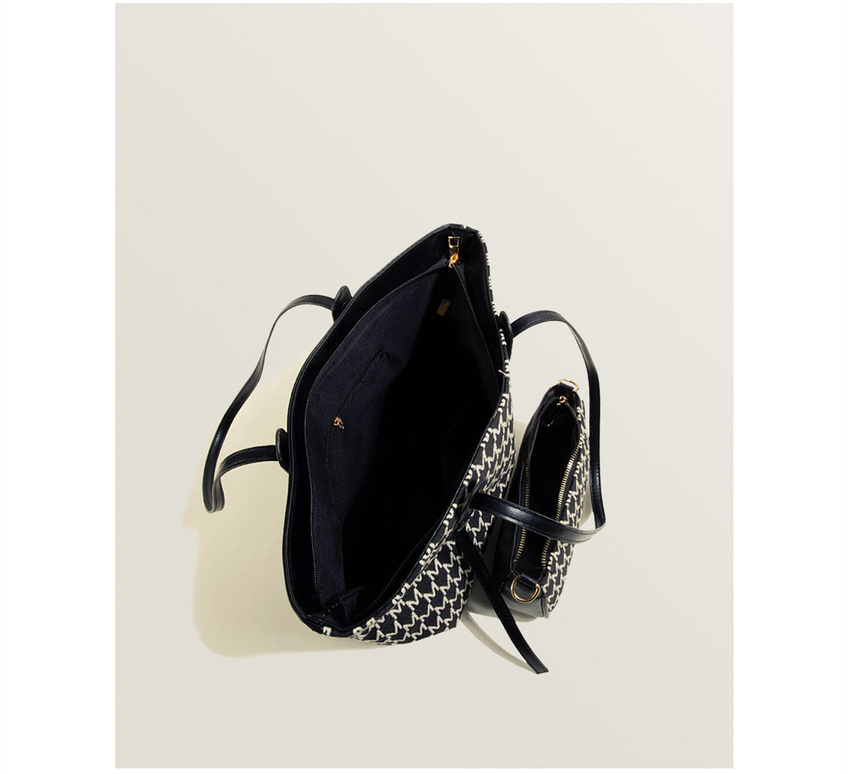 Black handbag with chain detail on a white background