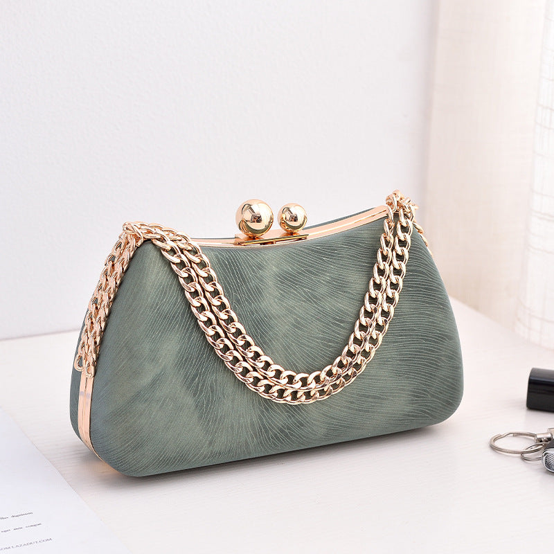 Green handbag with gold chain handle on a white background