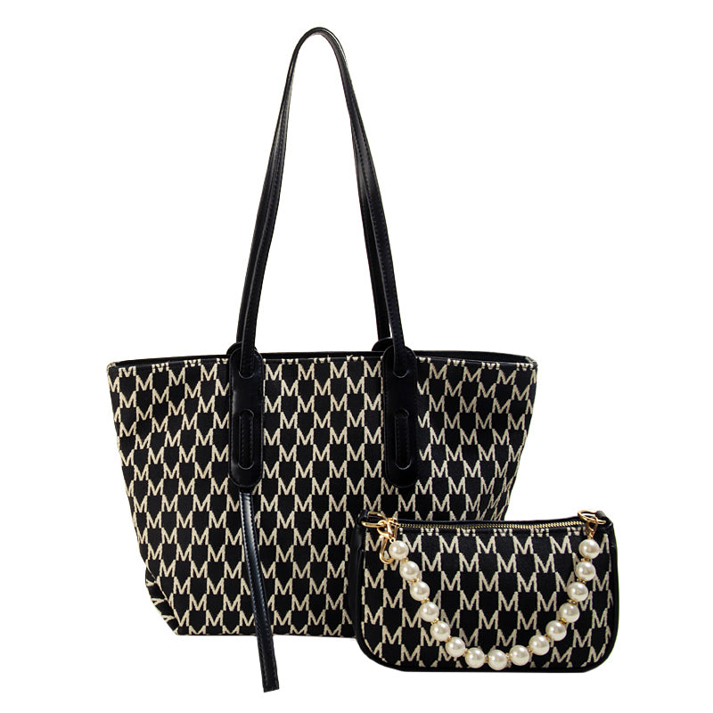 Black and white patterned handbag with matching pouch on a white background