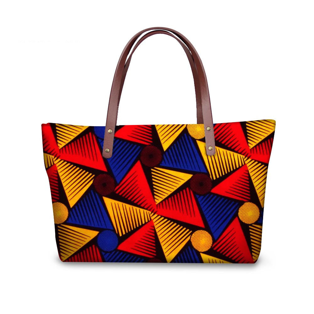 Colorful geometric patterned handbag with brown handle on a white background