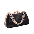 Black handbag with gold chain handle on a white surface