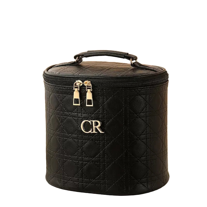 Black quilted makeup bag with gold accents on a white background