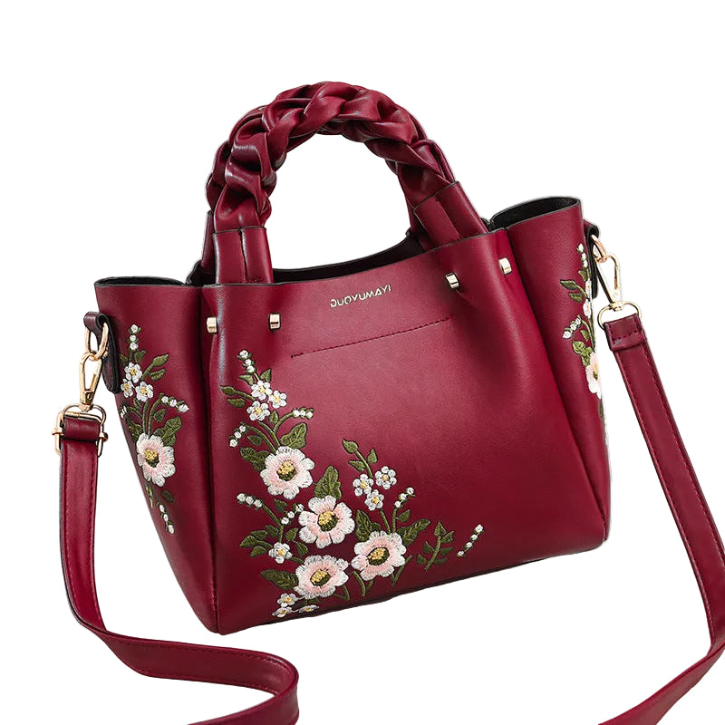 Red handbag with floral embroidery on a white background