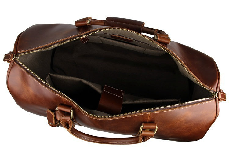 Brown leather duffel bag with gold zipper on a white background