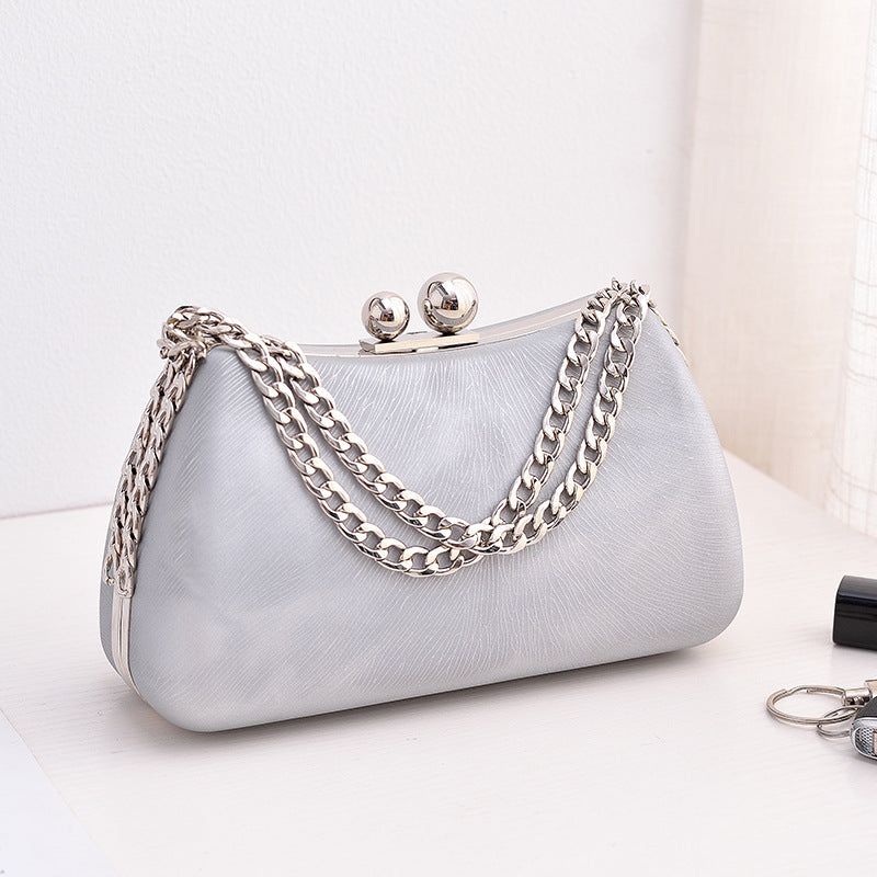 Light blue handbag with silver chain strap on a white background