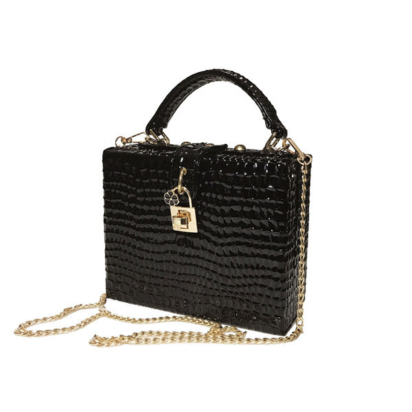 Black textured handbag with a gold chain and lock on a white background
