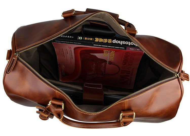 Brown leather duffel bag with a book inside on a white background