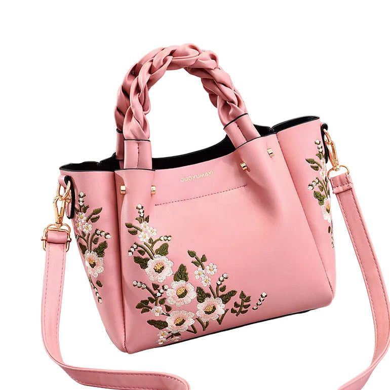 Pink handbag with floral embroidery on a white background