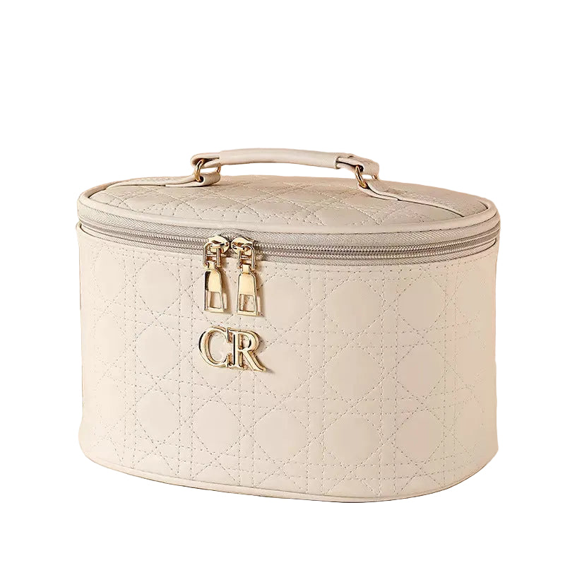 Quilted beige travel case with 'CR' initials on a  white background