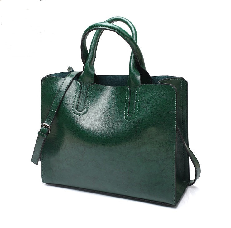 Green handbag with a shoulder strap on a white background