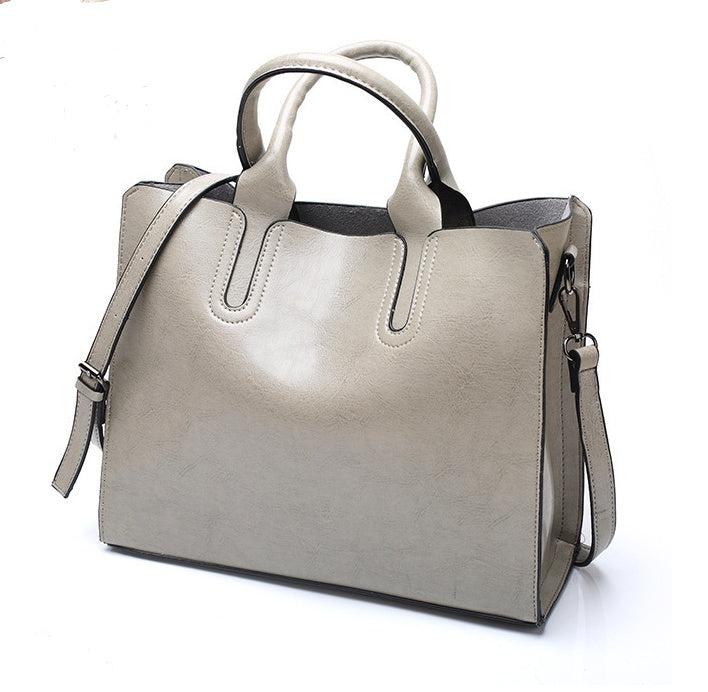 Gray handbag with a shoulder strap on a white background