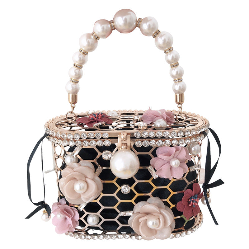 Decorative handbag with floral and pearl embellishments on a white background