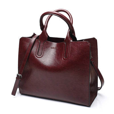 Brown leather handbag with a shoulder strap on a white background