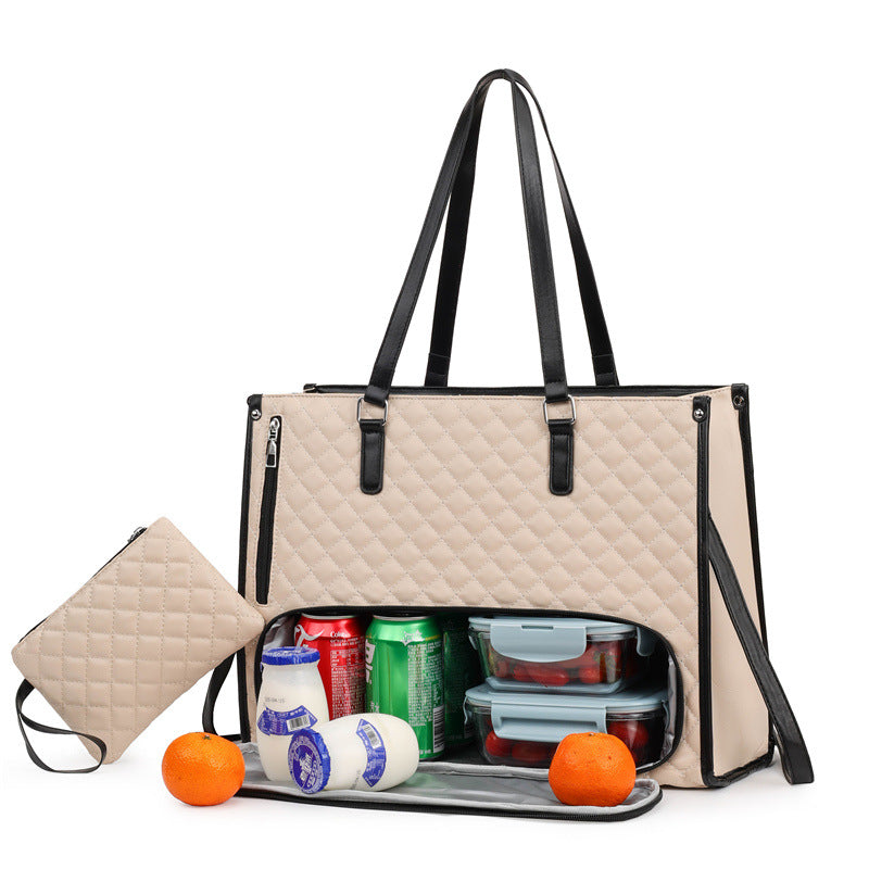 Beige tote bag with black handles and trim, containing snacks and drinks on a white background