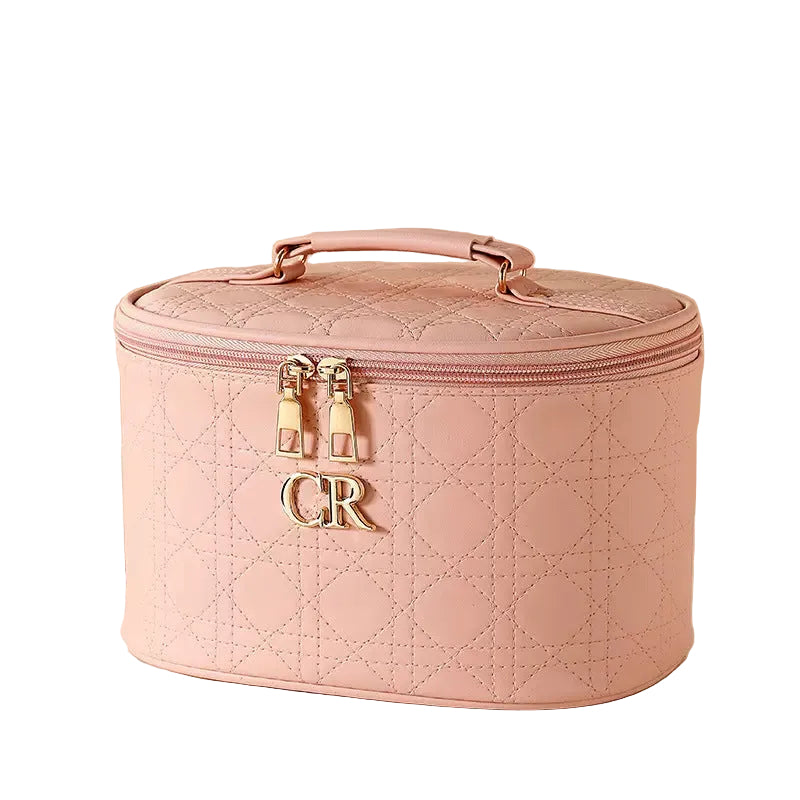 Pink quilted makeup case with 'CR' initials on a white background