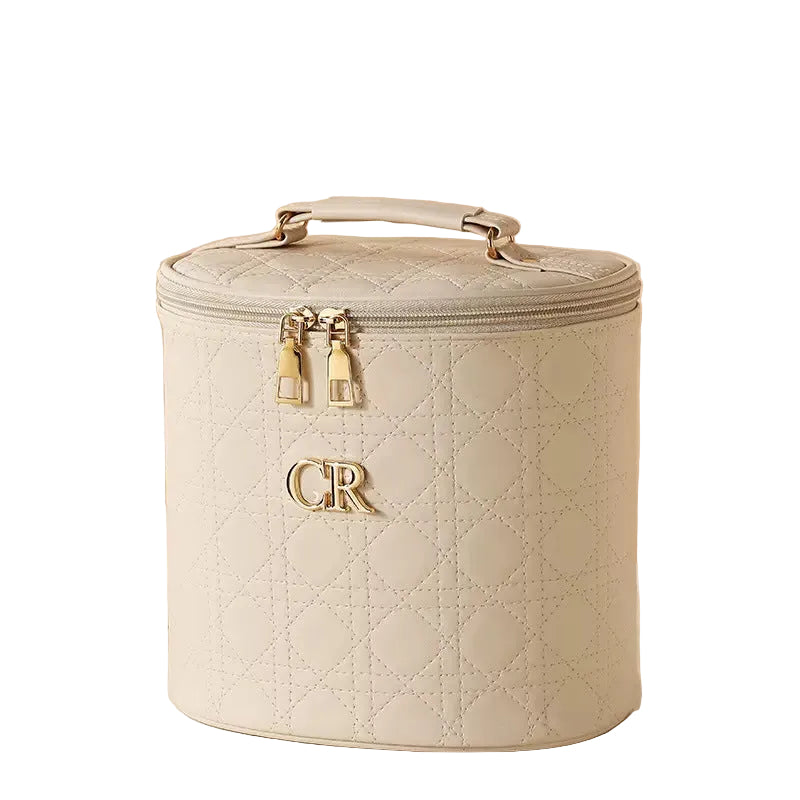 Quilted beige beauty case with gold accents on a white background