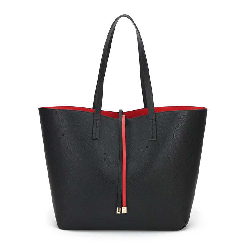 Black tote bag with a red zipper on a white background