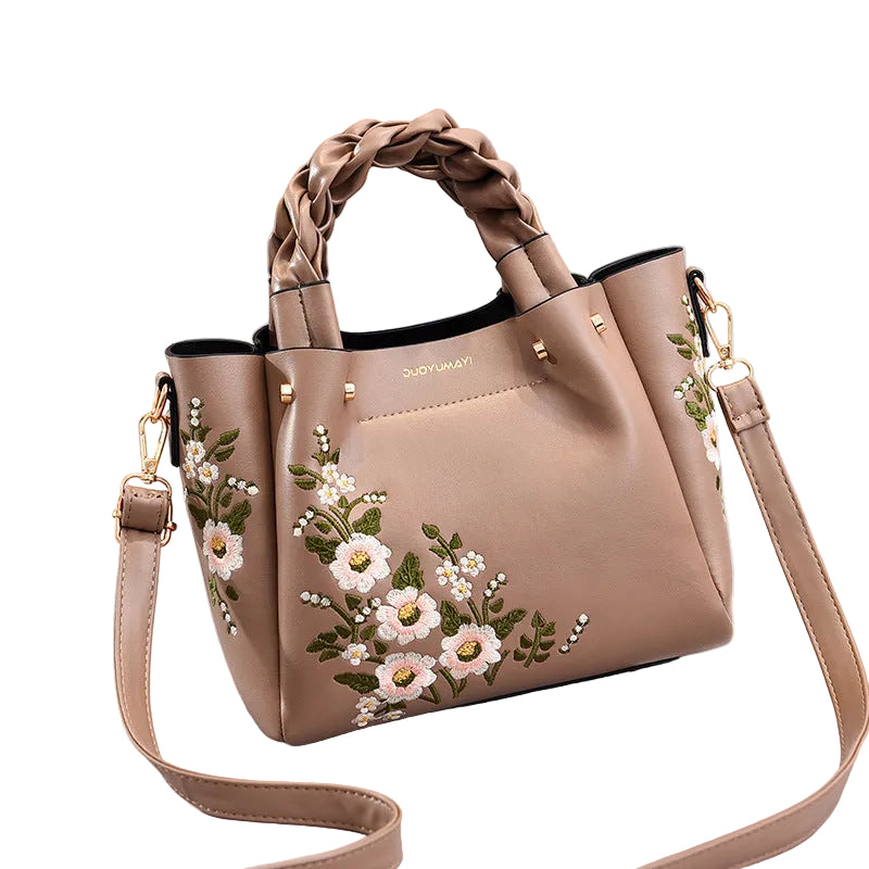 Beige handbag with floral embroidery on a white background