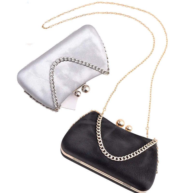 Black clutch bag with gold chain strap on a white surface