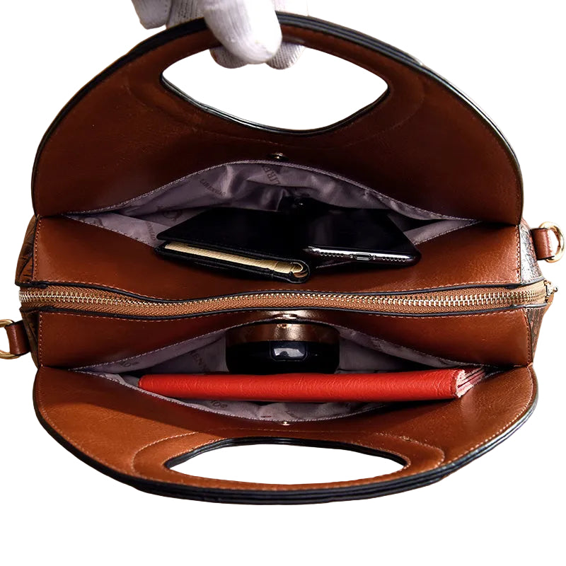 Brown leather handbag with a white glove holding it open, showing its interior.