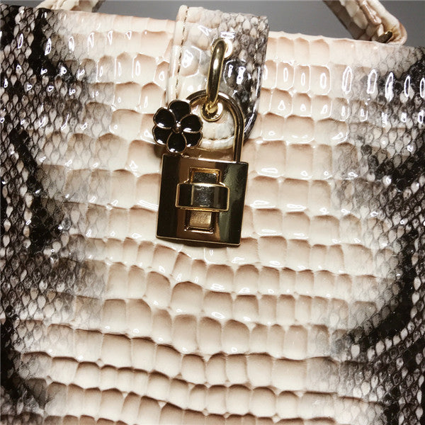 Close-up of a gold padlock charm on a textured surface