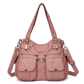 Pink handbag with multiple pockets and straps on a white background