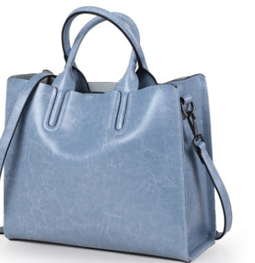 Blue handbag with a shoulder strap on a white background