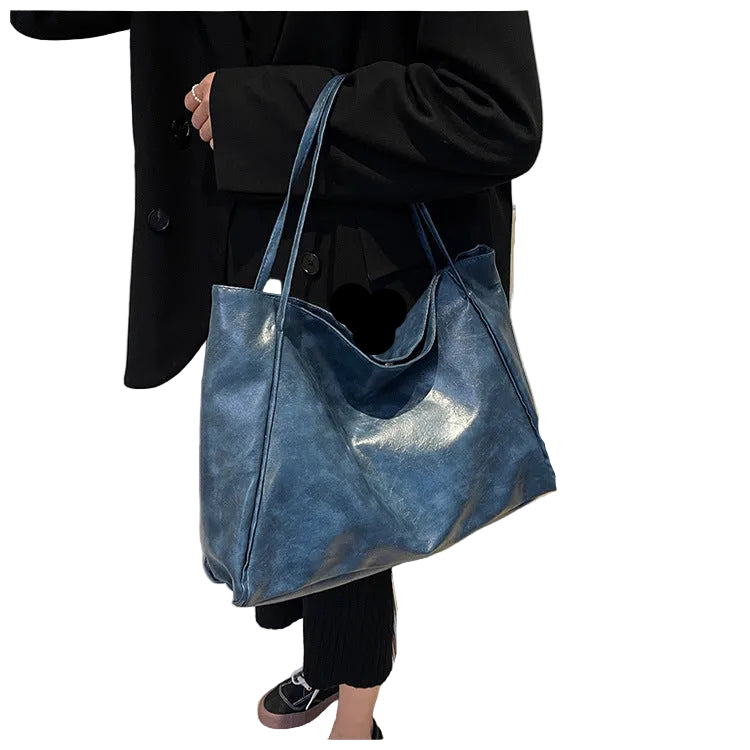 Person holding a blue shiny handbag on a white background