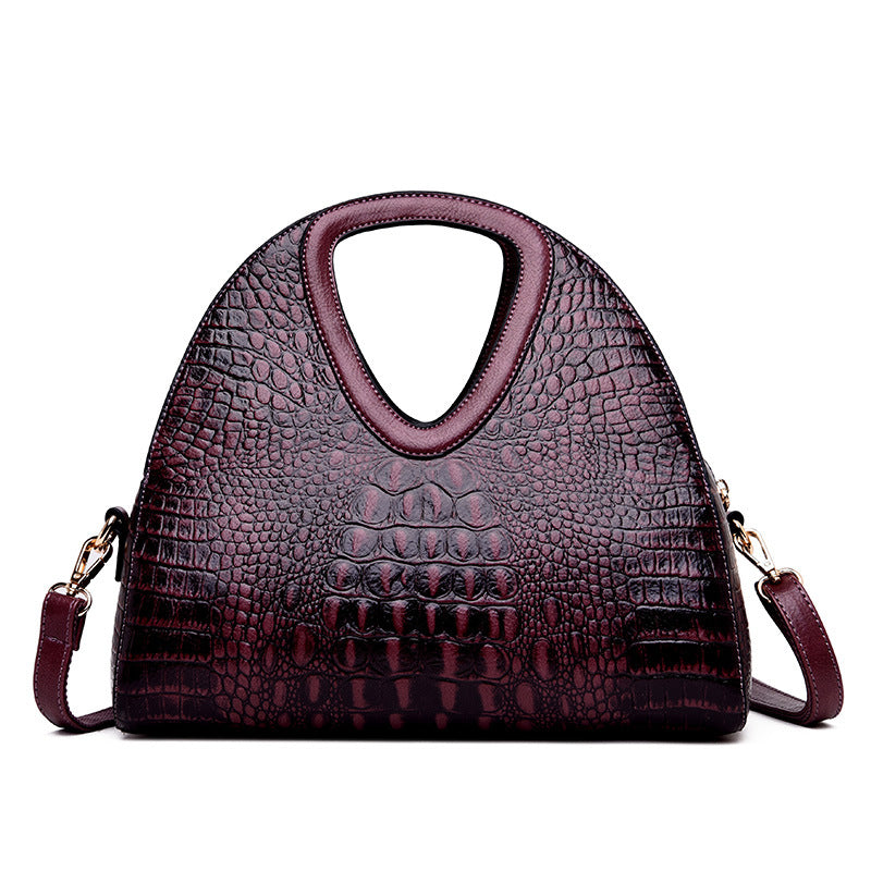 Purple textured handbag with a shoulder strap on a white background