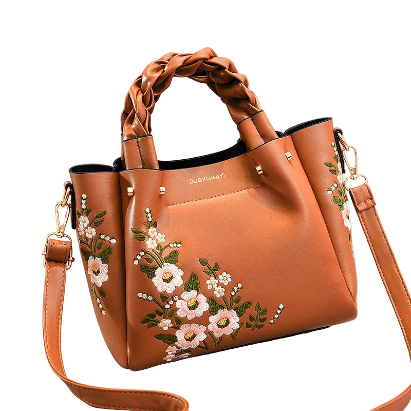 Brown handbag with floral embroidery on a white  gray background